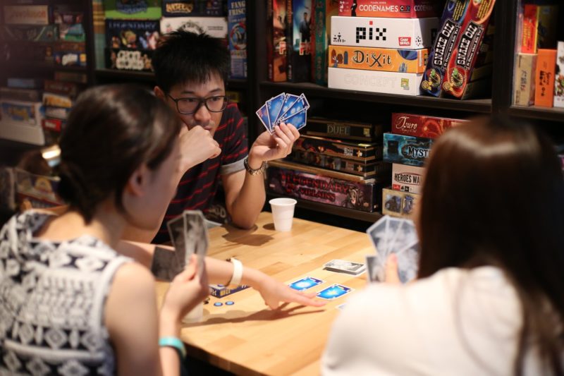 communication workshops for NGOs, corporations and schools. Those workshops can include learning how to play the card game Hanabi, that Regina gets to try out with Vince during the interview.